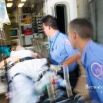 EMT workers putting an injured person in ambulance.