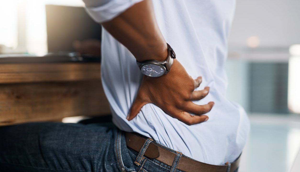 person with back pain in office