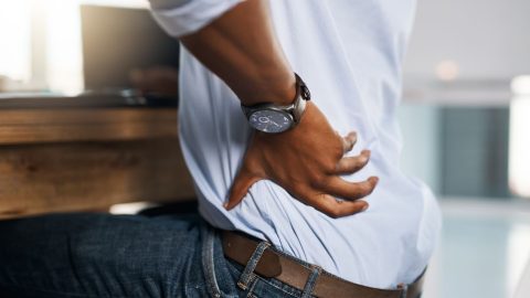 person with back pain in office